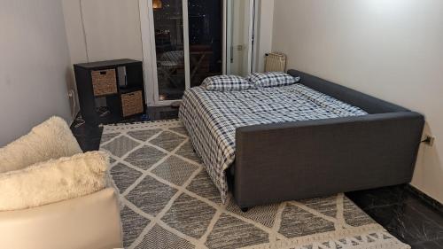 a bedroom with a bed and a chair in it at Acropolis View Condo, perfect location! in Piraeus