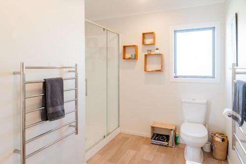 a bathroom with a shower and a toilet at Reel retreat - sunny with views! in Waihi Beach