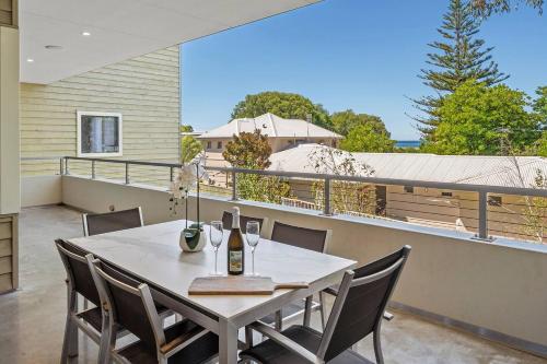 a dining table on the balcony of a house at Bayscape - Modern Beachside Retreat with Ocean View in Dunsborough