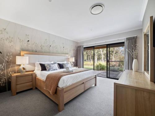 una camera da letto con un letto grande e una grande finestra di Bickley's Place - A Luxury Retreat on the Golf Green a Dunsborough