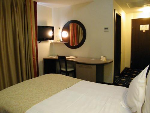 a hotel room with a bed and a desk at Hotel Berthelot in Bucharest