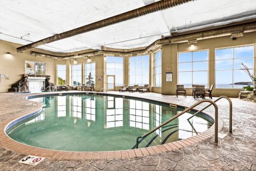 a large swimming pool in a building with windows at Amazing Superior Lake View Condo and Heated Pools in Two Harbors