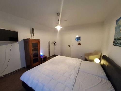 a bedroom with a large white bed and a tv at Holiday apartment with 2 bedrooms in Sassnitz