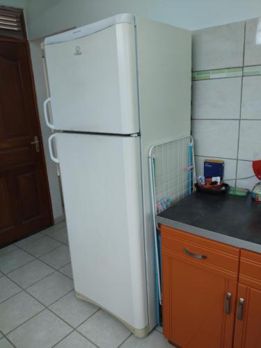a white refrigerator in a kitchen next to a counter at Pagerie bas de villa in Les Trois-Îlets