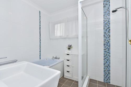 un bagno bianco con doccia e lavandino di Windella Cottage a North Rothbury