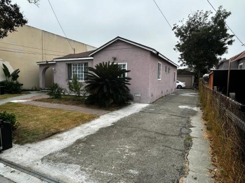 a small pink house on a street at 洛杉矶东部花园式独立屋暂停 in El Monte