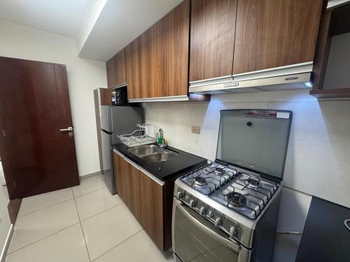 a small kitchen with a stove and a sink at Beautiful Family Apartment with Pool WiFi Central Team in Santa Cruz de la Sierra