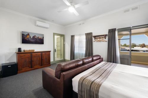 a bedroom with a large bed and a couch at George Inn Rooms at Royal Tenterfield in Tenterfield