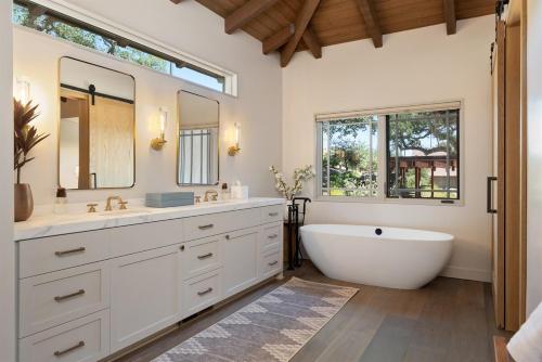 a bathroom with a tub and a sink and two windows at Oaks & Madeira A Luxury Wine Escape in Paso Robles in Paso Robles