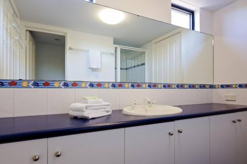 a bathroom with a sink and a mirror at Bondys Beach House - Panoramic Beachside Living in Prevelly