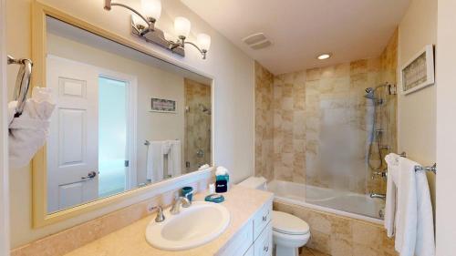 ein Badezimmer mit Waschbecken, Toilette und Spiegel in der Unterkunft South Bay Beach Club #31- 3 Bedroom 2 Bathroom Unit in George Town
