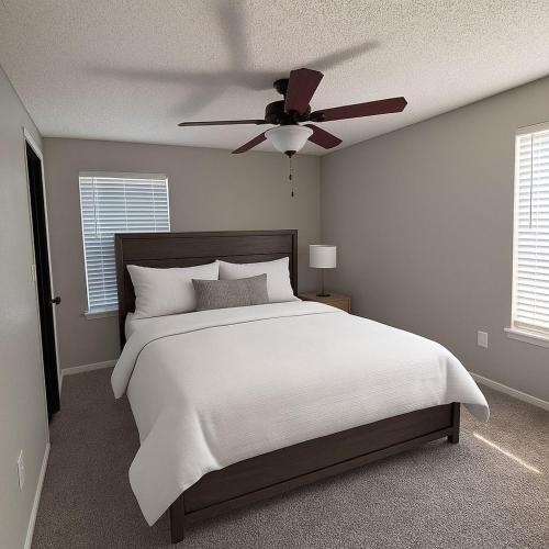 a bedroom with a bed with a ceiling fan at Modern & Cozy Apartment Stay in Olathe