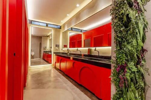 a kitchen with red cabinets and a green wall at Studio Aconchego - 2 Bedrooms with Wi-Fi Subway in Sao Paulo
