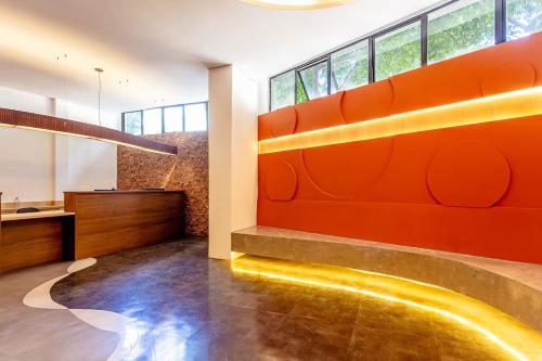 a lobby with an orange wall and a counter at Studio Aconchego - 2 Bedrooms with Wi-Fi Subway in Sao Paulo