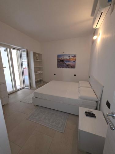 Un dormitorio blanco con una cama y un sofá. en The Dreams Palace, en Porto San Paolo