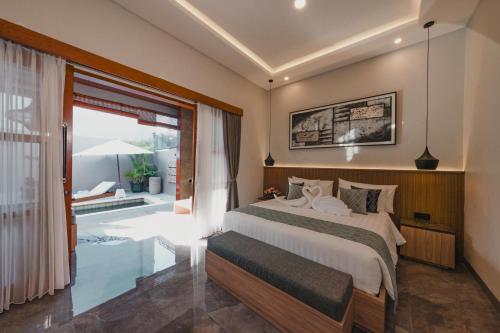 a bedroom with a bed and a large window at Dikubu Belong VILLA in Denpasar