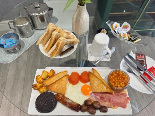 a plate of breakfast food on a glass table at Reads Avenue 1 Bed Apartment - Next To H&A Social Club - Minutes from Winter Gardens & Town Centre! in Blackpool