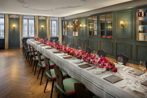 a long table in a room with red roses at Hotel Goldener Hirsch, A Luxury Collection Hotel, Salzburg in Salzburg