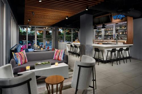 a restaurant with a couch and chairs and a bar at Aloft Miami Dadeland in Kendall