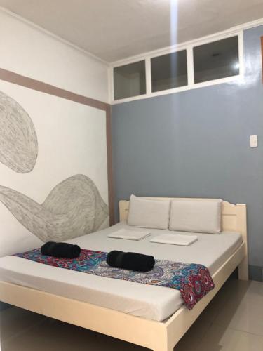 a bedroom with a bed with two black hats on it at Traveler's Home in Cebu City