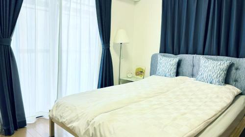 京都夏様香驛 Spacious 4 Bedroom Kyoto House with 2 Bathrooms,2 Toilets ,Sleeps up to 8的一间卧室配有一张蓝色窗帘的床