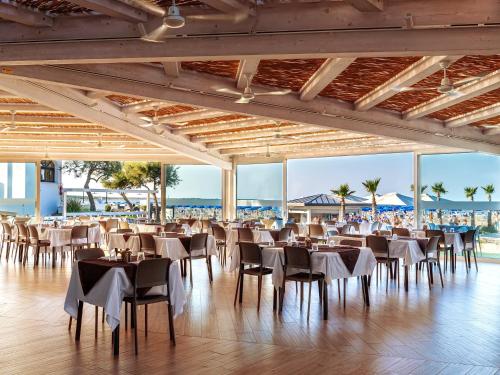 a banquet hall with tables and chairs and the beach at Apartment in Albarella near Beach & Activities in Palazzo Vianello
