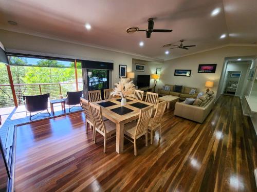 a living room with a table and chairs and a couch at Avoca Holiday House Fraser Island in Kingfisher Bay