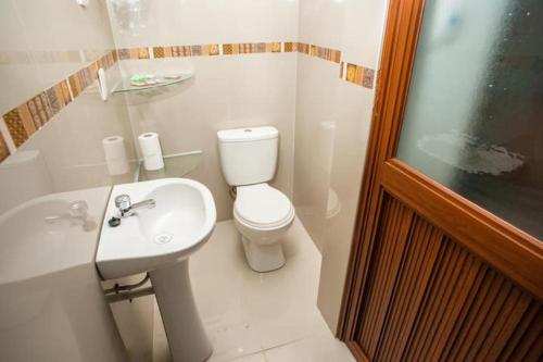Un baño blanco con inodoro y lavabo. en Cristallina downtown, en Puno
