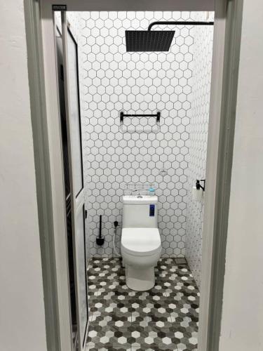 a bathroom with a white toilet in a room at Azlynie Homestay in Kangar