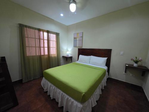 a bedroom with a green bed and a window at Hotel Casona Macondo, Granada, Nicaragua in Granada