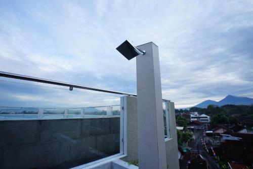 a light on a balcony with a view of a city at Casa de Java Jogja in Kejayan