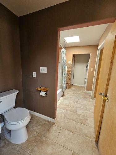 a bathroom with a toilet and a hallway at Casita La Mesilla in Espanola