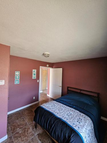 a bedroom with a bed in a room with red walls at Casita La Mesilla in Espanola