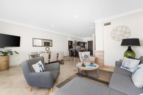 a living room with two chairs and a table at Condo Maravilla - New luxurious condo 300mt from the beach in Cabo San Lucas