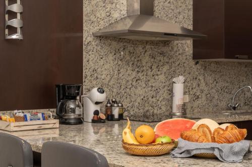 a kitchen counter with a basket of fruit and bread at Condo Maravilla - New luxurious condo 300mt from the beach in Cabo San Lucas