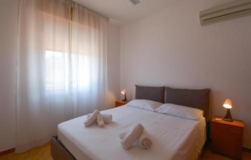a bedroom with a white bed with two pillows on it at Beautiful Home In Marzamemi in Marzamemi
