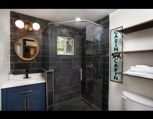 a bathroom with a shower with a sink and a mirror at Little Bear Hideaway in Sevierville
