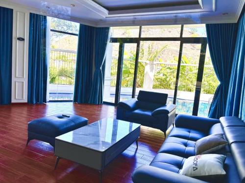 a living room with blue couches and a coffee table at Lakeside Đá Bàng Ecolodge, ấp Tân Hiệp, xã Long Tân, Huyện Đất Đỏ, BRVT in La Sơn