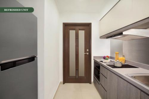 a kitchen with a sink and a wooden door at Somerset Grand Citra Jakarta in Jakarta