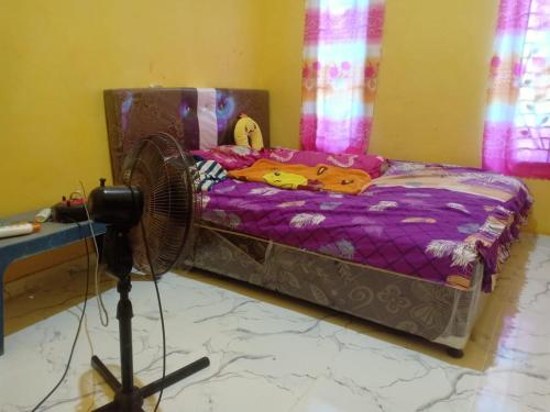 KinatiにあるAssyifa Homestayのベッドルーム1室(ファン付きのベッド1台付)