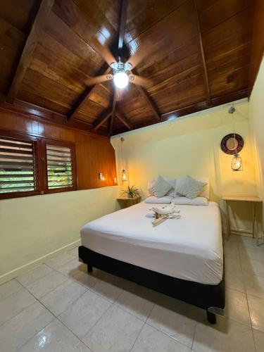 a bedroom with a large bed with a wooden ceiling at Maïa Bacalar in Bacalar