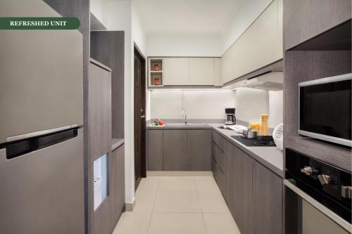 a kitchen with a sink and a microwave at Somerset Grand Citra Jakarta in Jakarta
