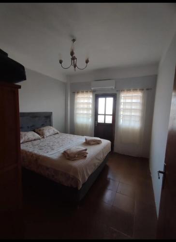 a bedroom with a large bed and a chandelier at Casa kira in Encarnación