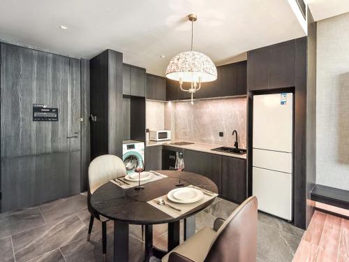 a kitchen with a table and chairs and a refrigerator at Yashihui Hotel in Qumul