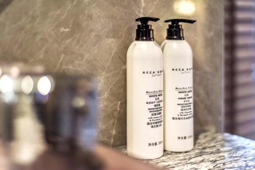 two white shampoo bottles sitting on a counter at Yashihui Hotel in Qumul