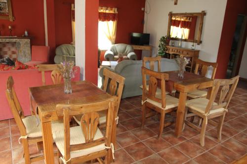 a living room with wooden tables and chairs at El Alamo Hotel in Comandante Luis Piedra Buena