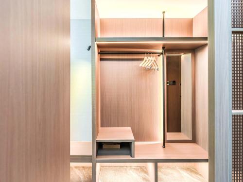 a dressing room with a mirror and a closet at Yashihui Hotel in Qumul
