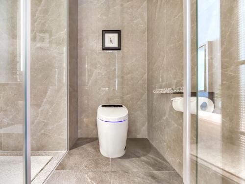 a bathroom with a toilet and a shower at Yashihui Hotel in Qumul