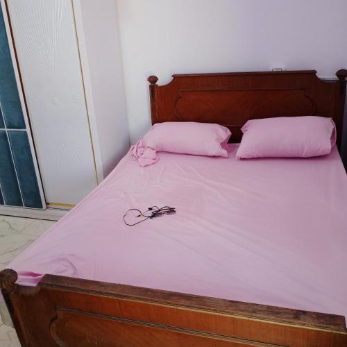 a bed with pink sheets and a pair of glasses on it at Roof Top Studio Apartment in New cairo