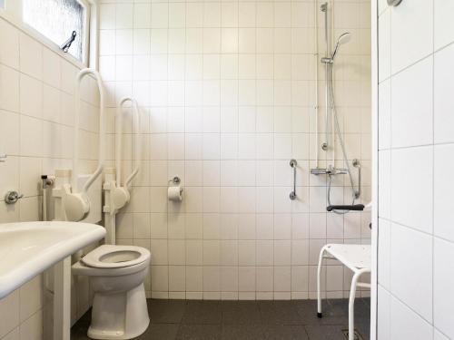 a bathroom with a toilet and a sink and a shower at Bungalow in Putten near Veluwe Forest in Putten